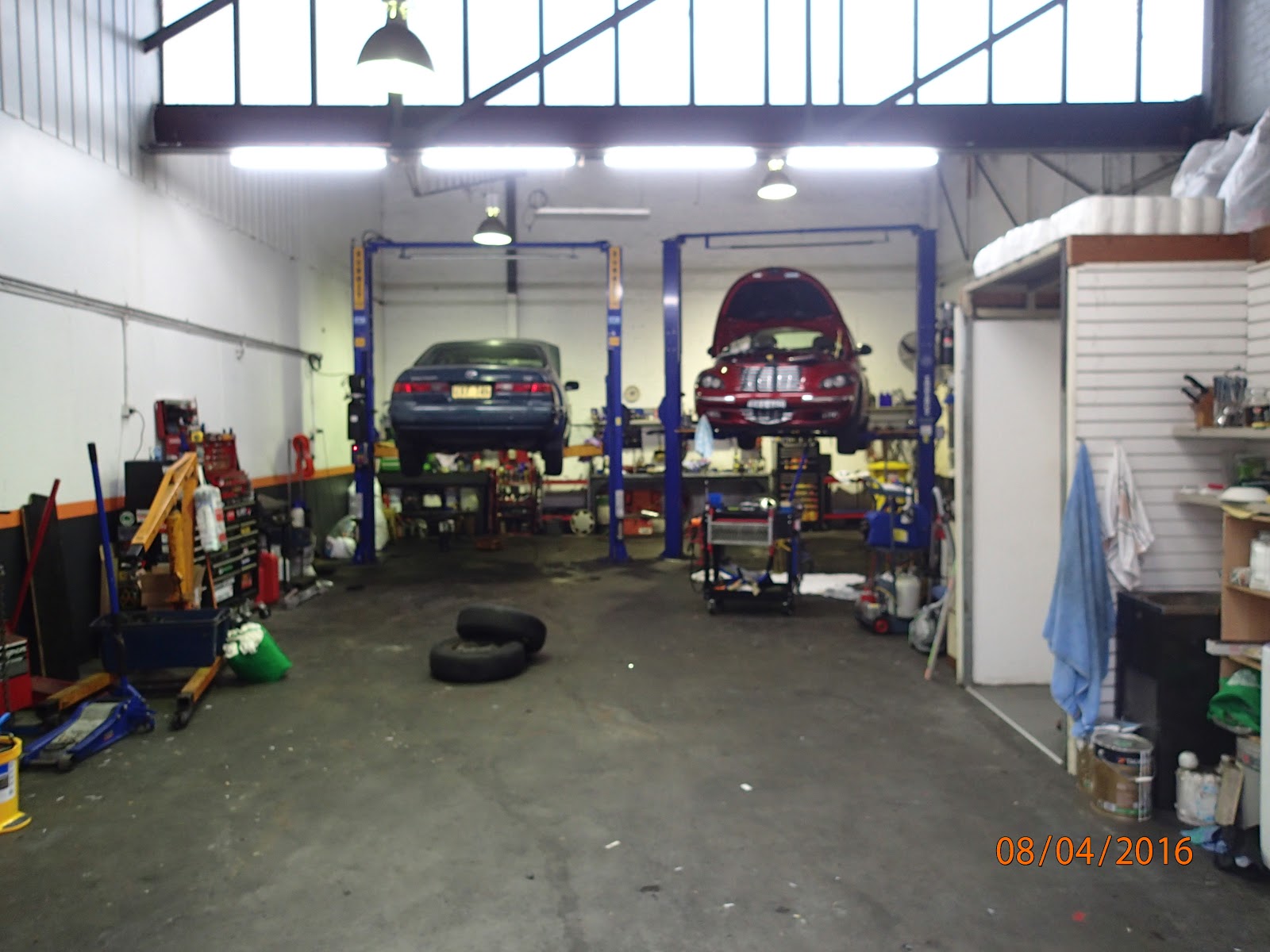 Two cars up on the hoists inside the Star Auto Electrics workshop in Gladesville
